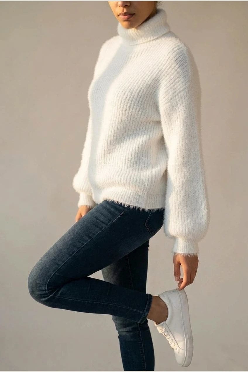 Model i lys, luftig rullekravesweater med ballonærmer, ribbede manchetter og kant, stylet med grå bukser og hvide sneakers._4