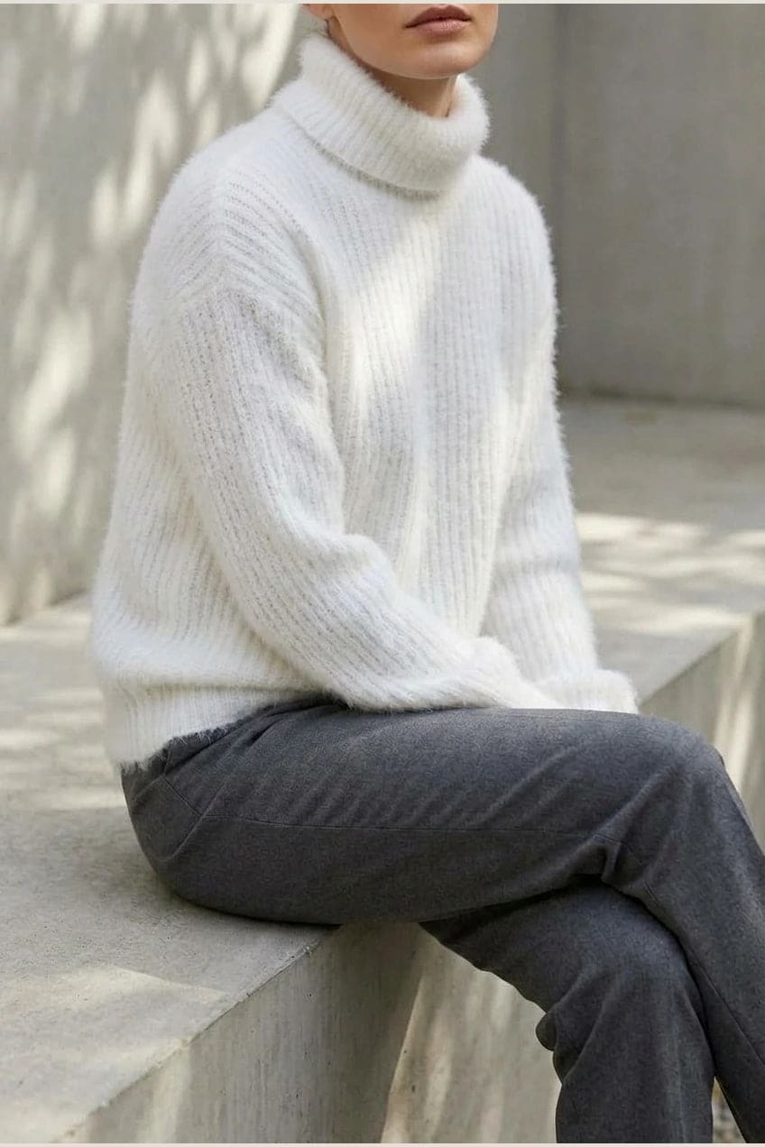Model i lys, luftig rullekravesweater med ballonærmer, ribbede manchetter og kant, stylet med grå bukser og hvide sneakers._5