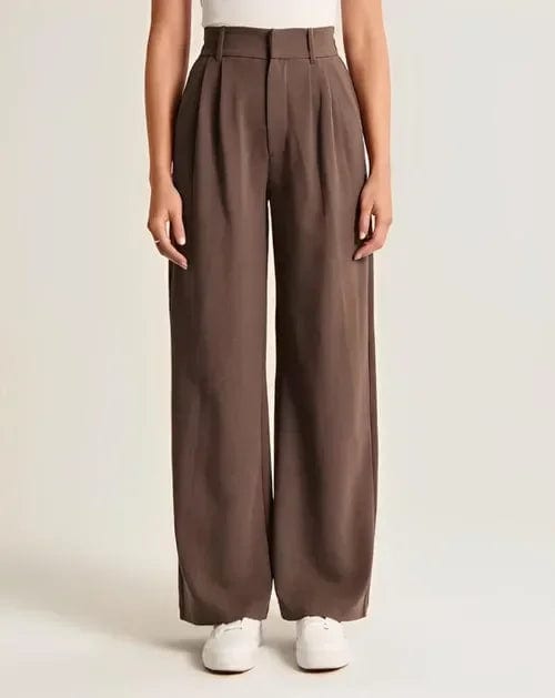 Kvinde iført lyse wide-leg bukser i høj talje, skræddersyet pasform, med cropped top og blazer._18