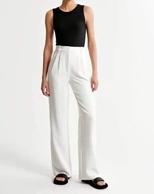 Kvinde iført lyse wide-leg bukser i høj talje, skræddersyet pasform, med cropped top og blazer._19