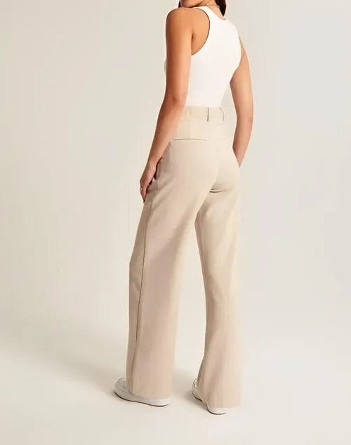 Kvinde iført lyse wide-leg bukser i høj talje, skræddersyet pasform, med cropped top og blazer._21