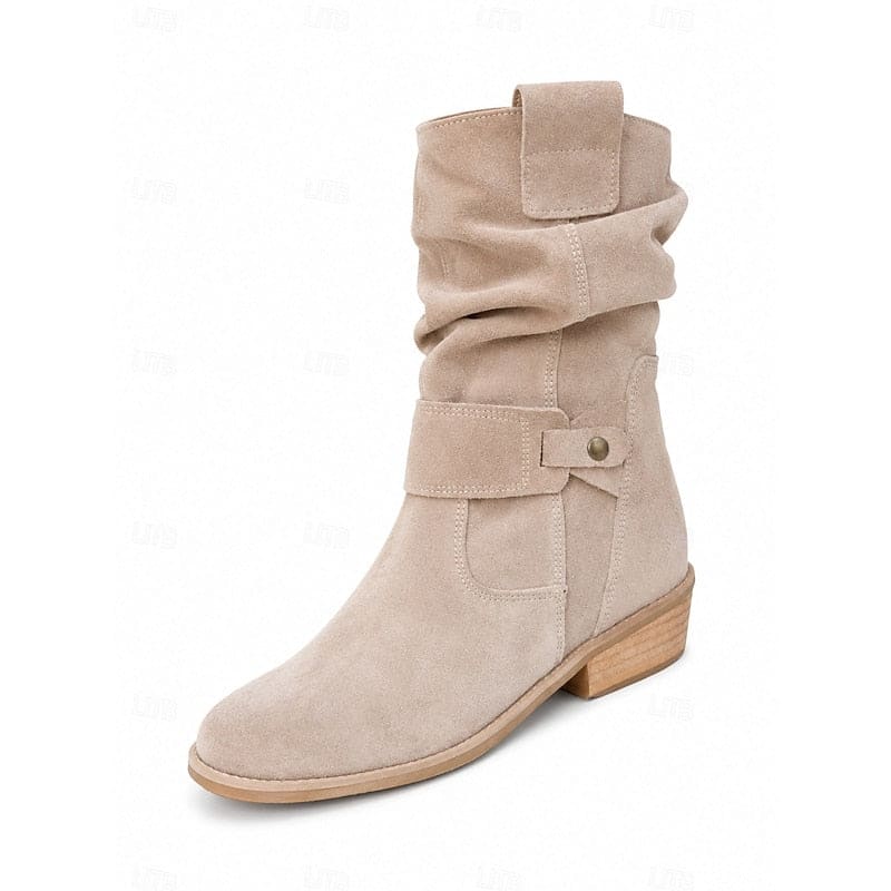 Kvinde bærer beige ankelstøvler med slouchy skaft, blokhæl og spændedetalje på flisegulv._3