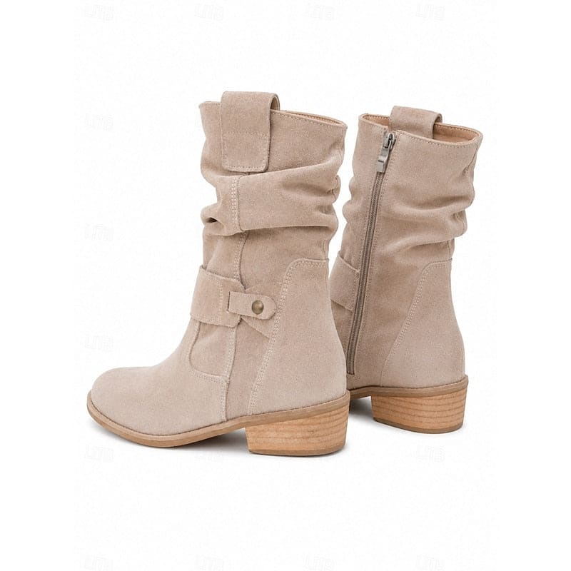 Kvinde bærer beige ankelstøvler med slouchy skaft, blokhæl og spændedetalje på flisegulv._4