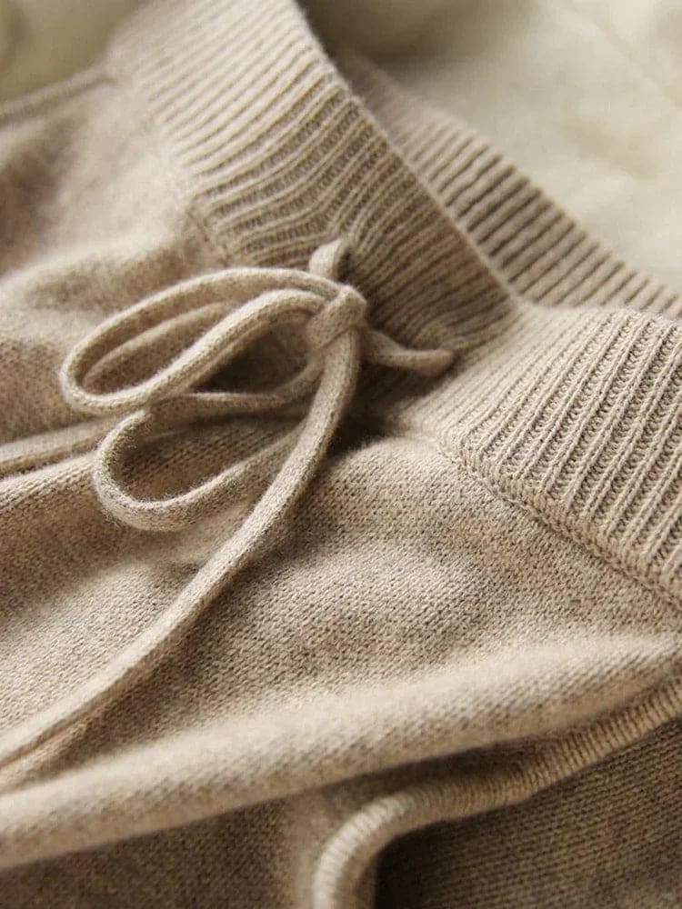 Model iført beige strikket sæt bestående af løstsiddende sweater og matchende nederdel med sliddetalje_21