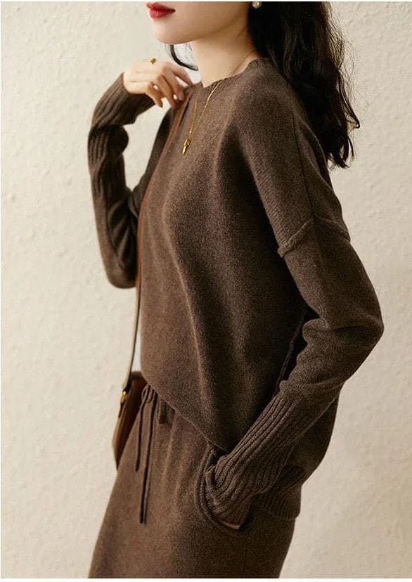 Model iført beige strikket sæt bestående af løstsiddende sweater og matchende nederdel med sliddetalje_22