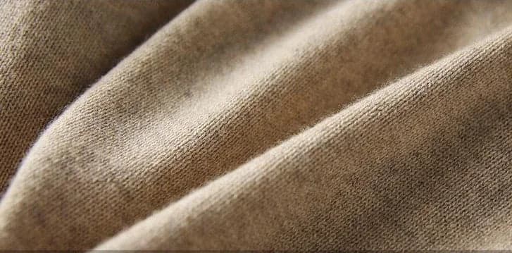 Model iført beige strikket sæt bestående af løstsiddende sweater og matchende nederdel med sliddetalje_24