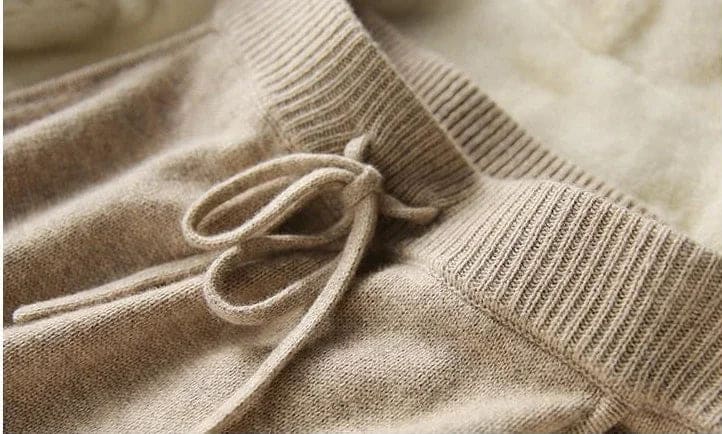 Model iført beige strikket sæt bestående af løstsiddende sweater og matchende nederdel med sliddetalje_26
