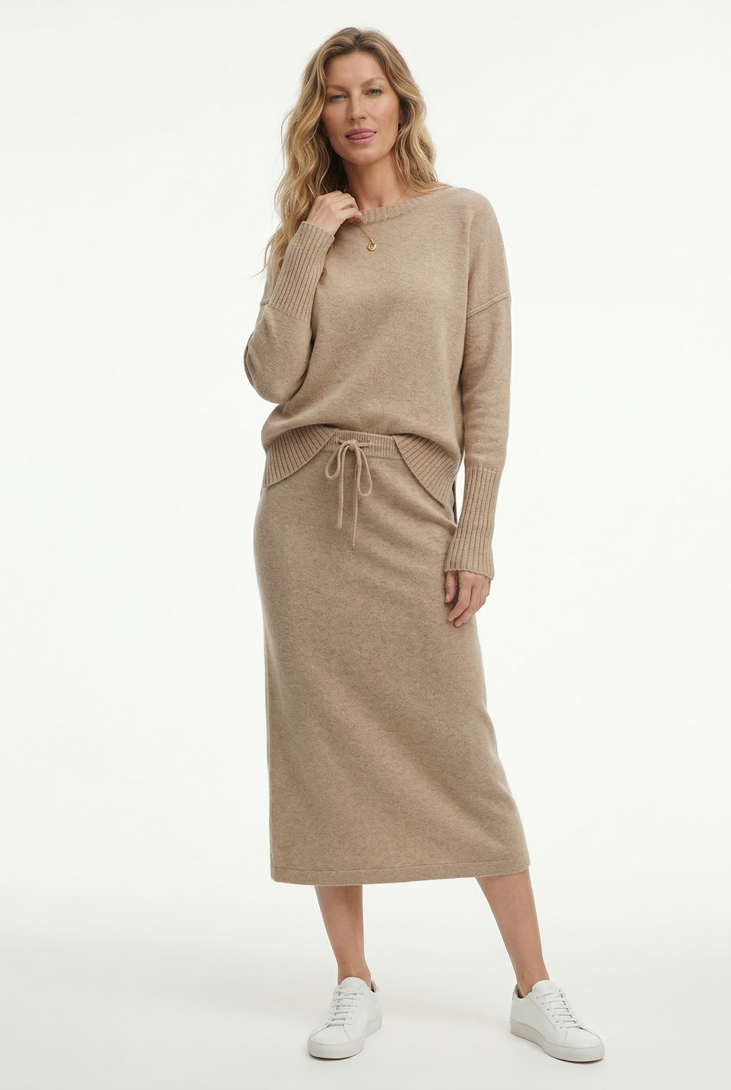 Model iført beige strikket sæt bestående af løstsiddende sweater og matchende nederdel med sliddetalje_6