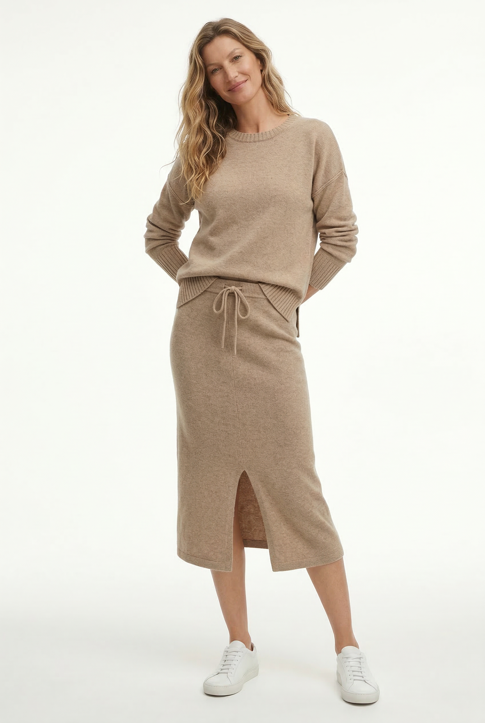 Model iført beige strikket sæt bestående af løstsiddende sweater og matchende nederdel med sliddetalje_7