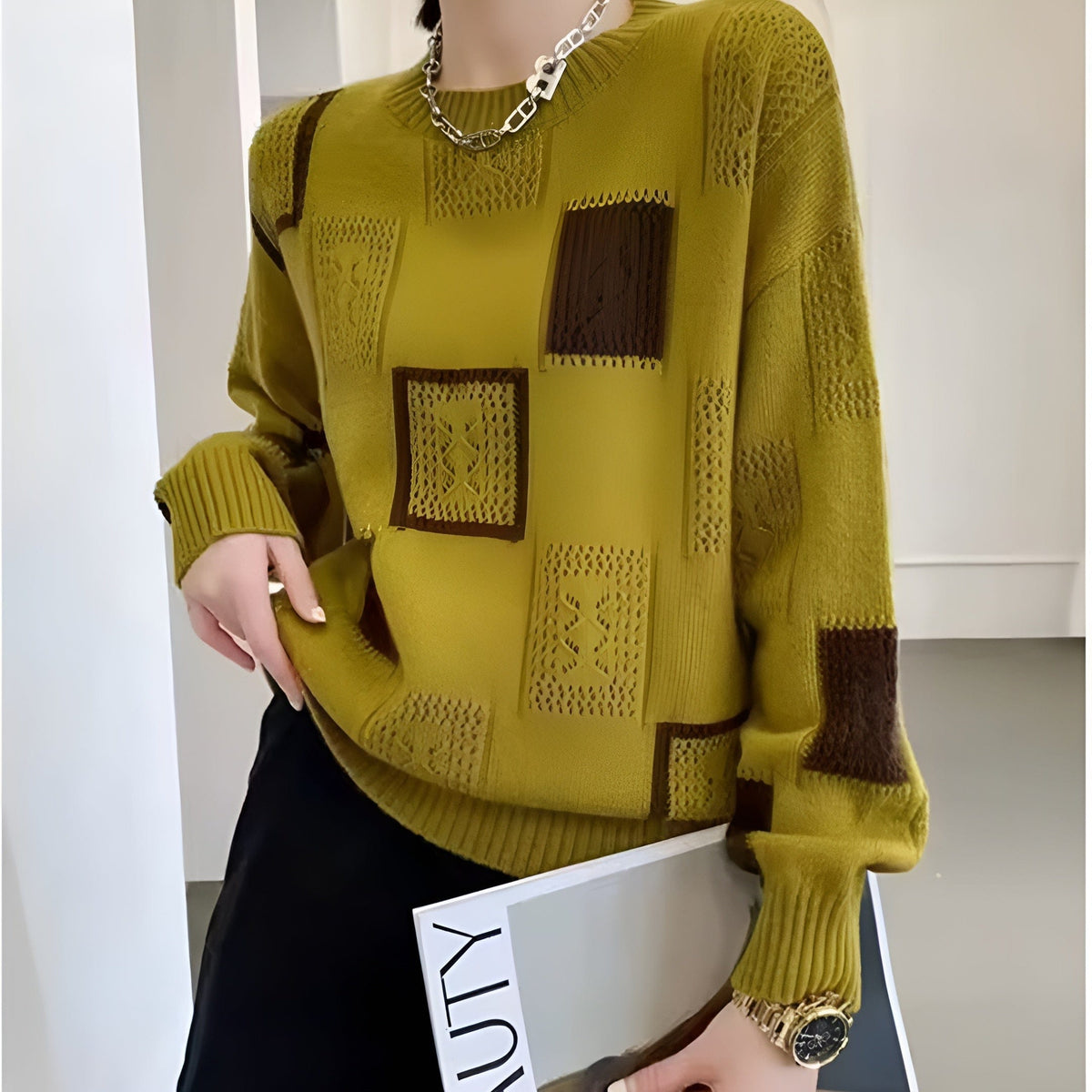 Kvinde iført hvid strikket sweater med sorte geometriske blokke i grafisk mønster og rund hals._4