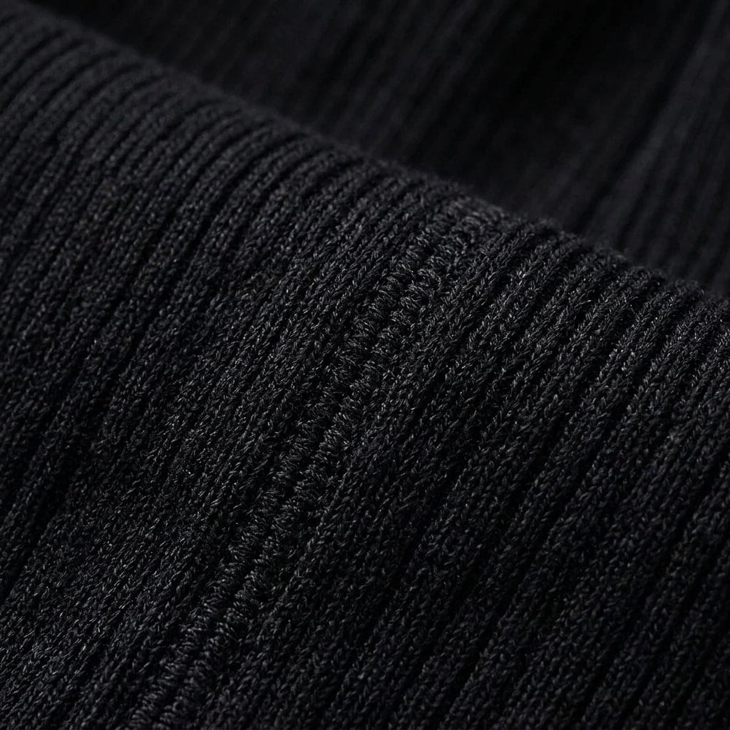 Kvinde iført lyserød strikket sweater med høj krave og slank pasform kombineret med hvide bukser i lyst dagslys_9