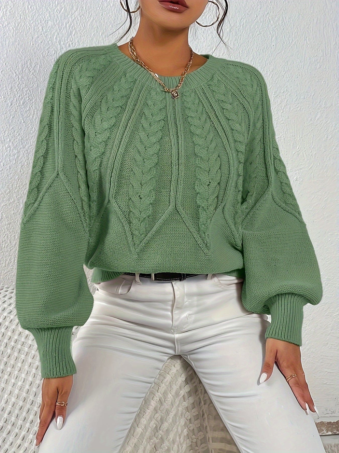 Kvinde set bagfra iført strikket sweater med kabelmønster og ballonærmer._1