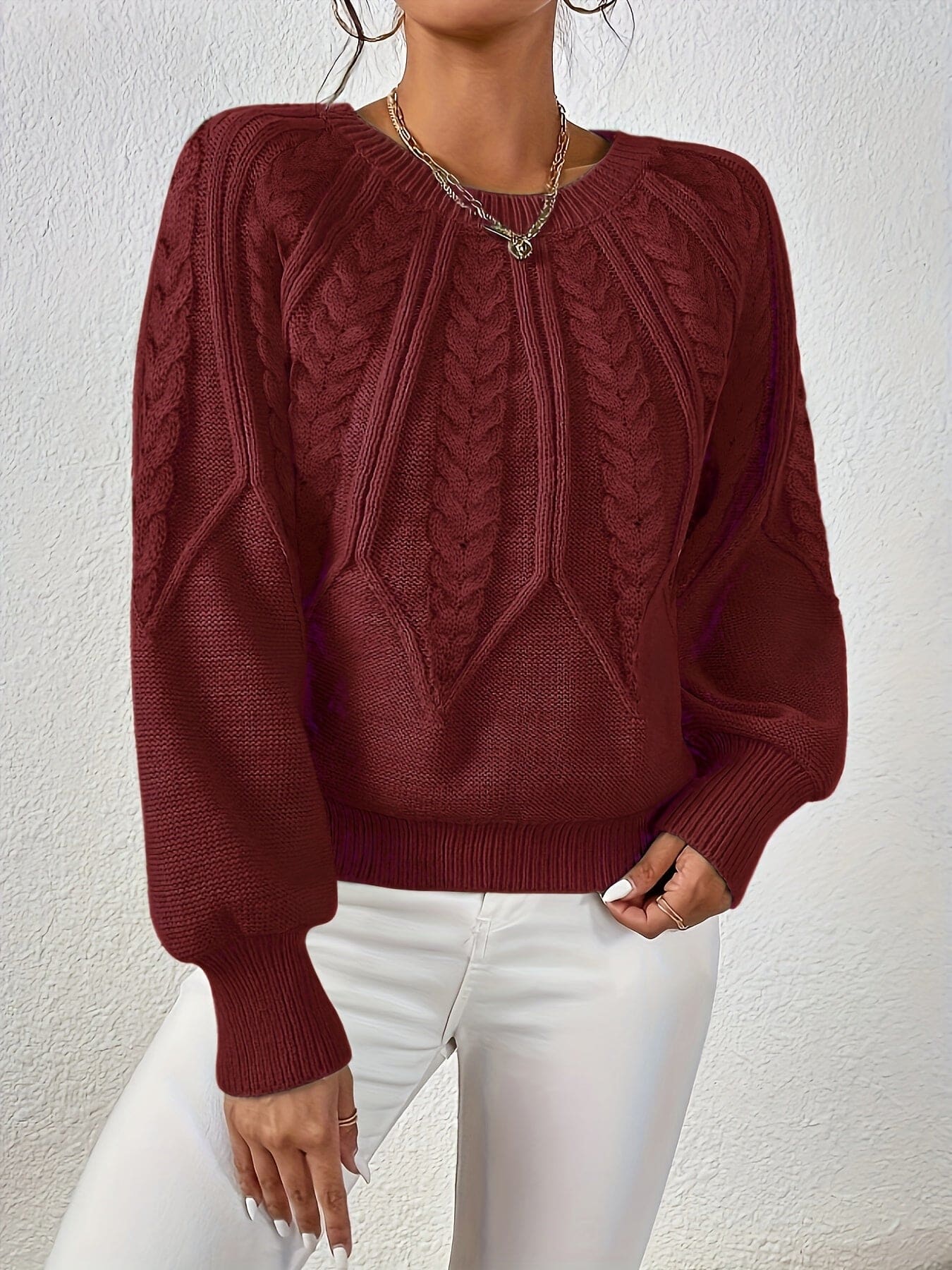 Kvinde set bagfra iført strikket sweater med kabelmønster og ballonærmer._12
