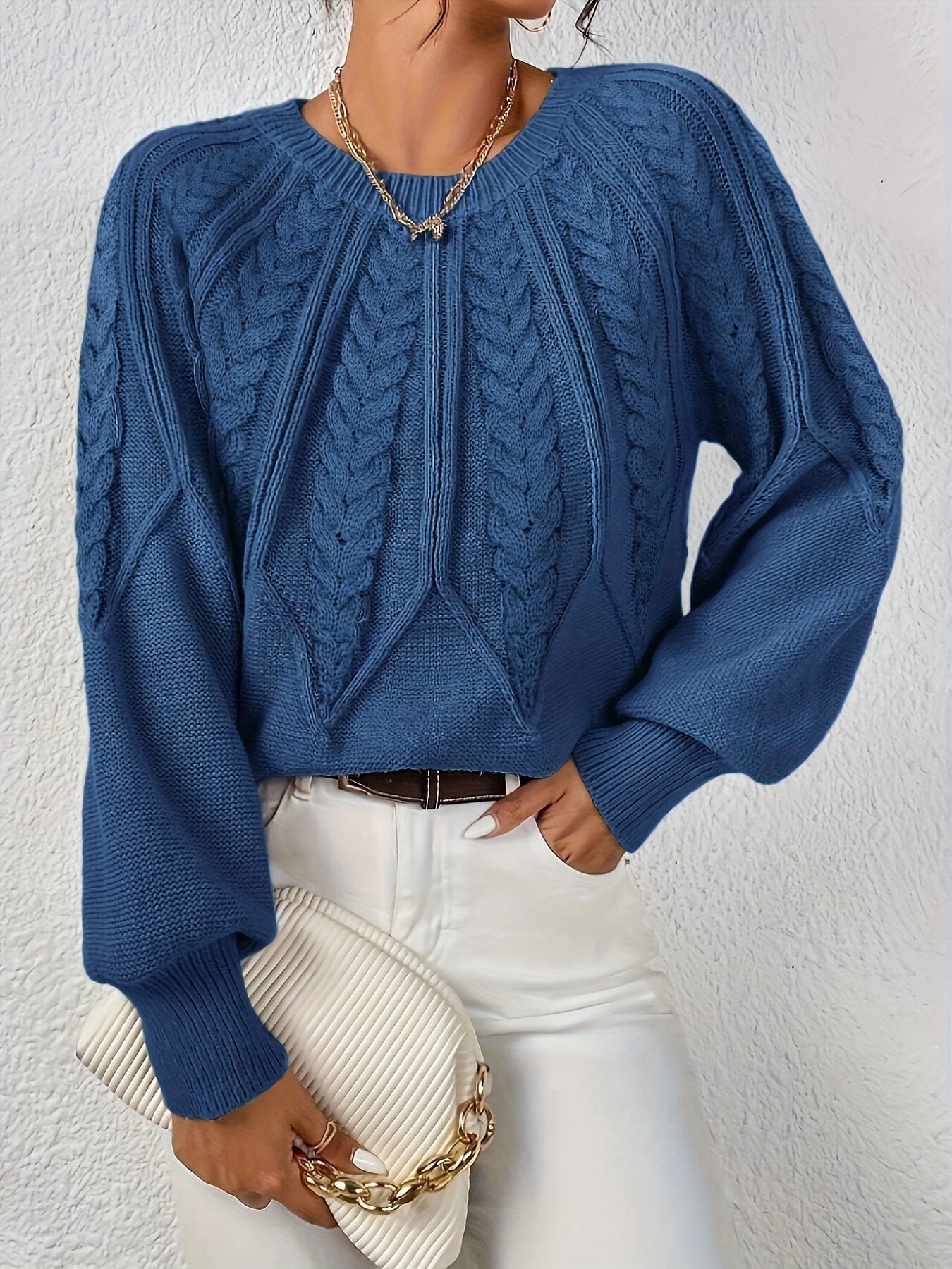 Kvinde set bagfra iført strikket sweater med kabelmønster og ballonærmer._14