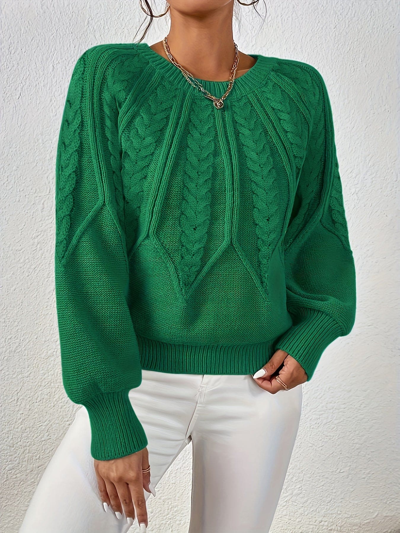 Kvinde set bagfra iført strikket sweater med kabelmønster og ballonærmer._19