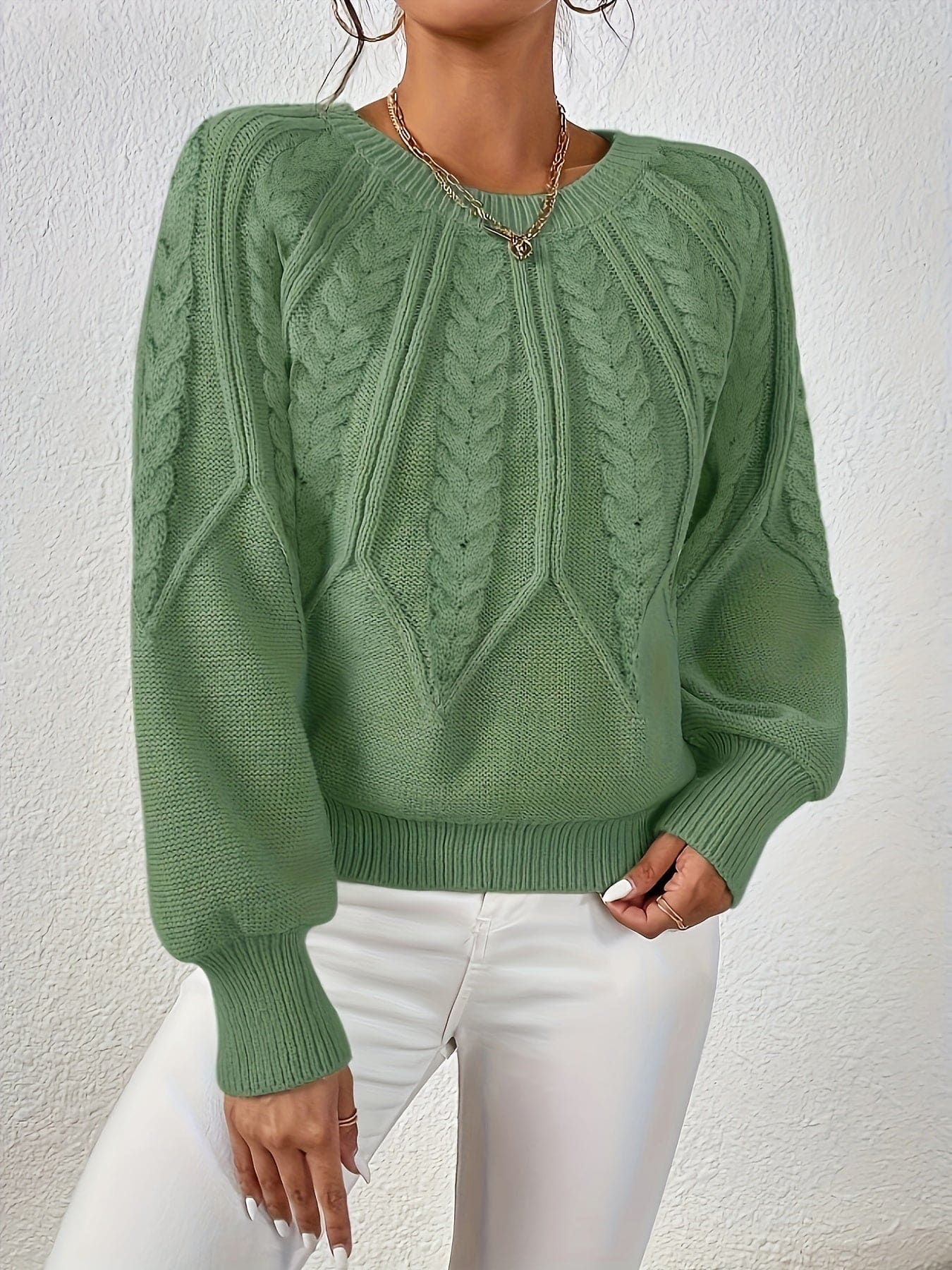 Kvinde set bagfra iført strikket sweater med kabelmønster og ballonærmer._2