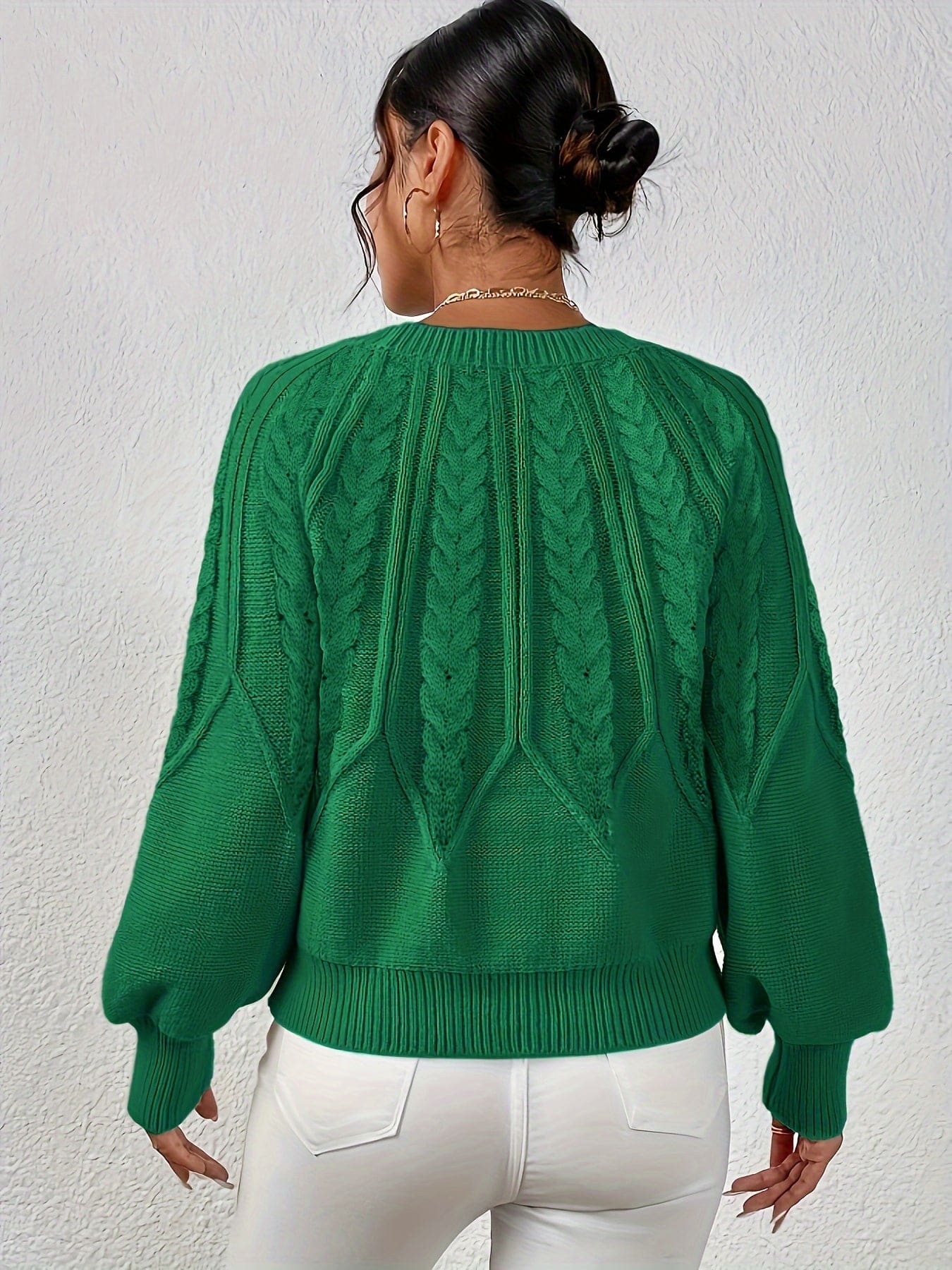 Kvinde set bagfra iført strikket sweater med kabelmønster og ballonærmer._20