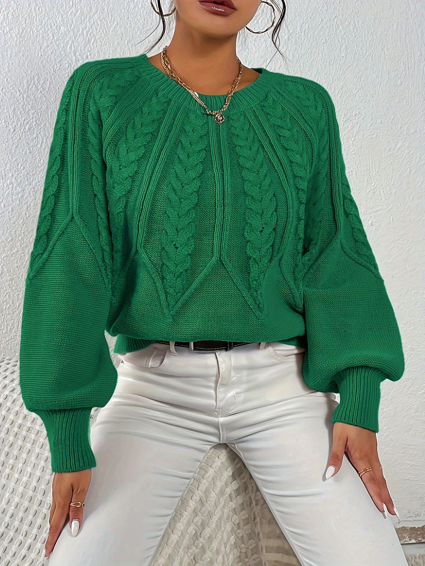 Kvinde set bagfra iført strikket sweater med kabelmønster og ballonærmer._21