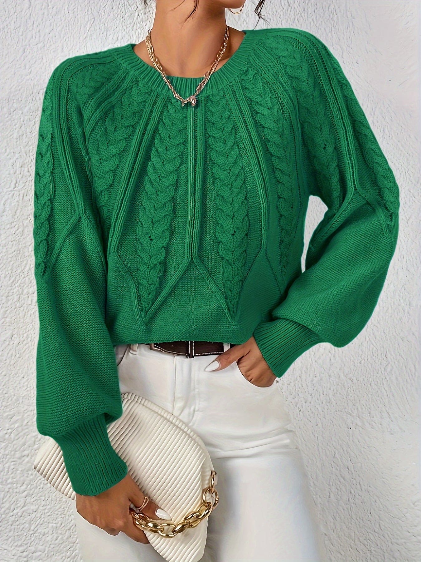 Kvinde set bagfra iført strikket sweater med kabelmønster og ballonærmer._22