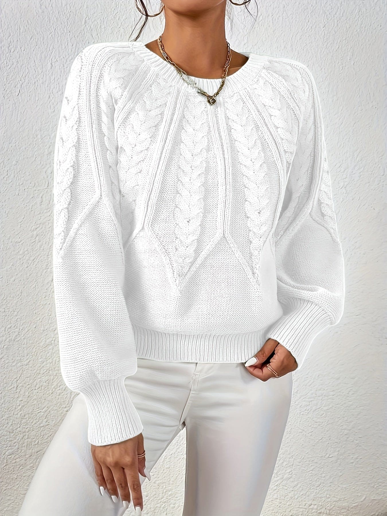 Kvinde set bagfra iført strikket sweater med kabelmønster og ballonærmer._29