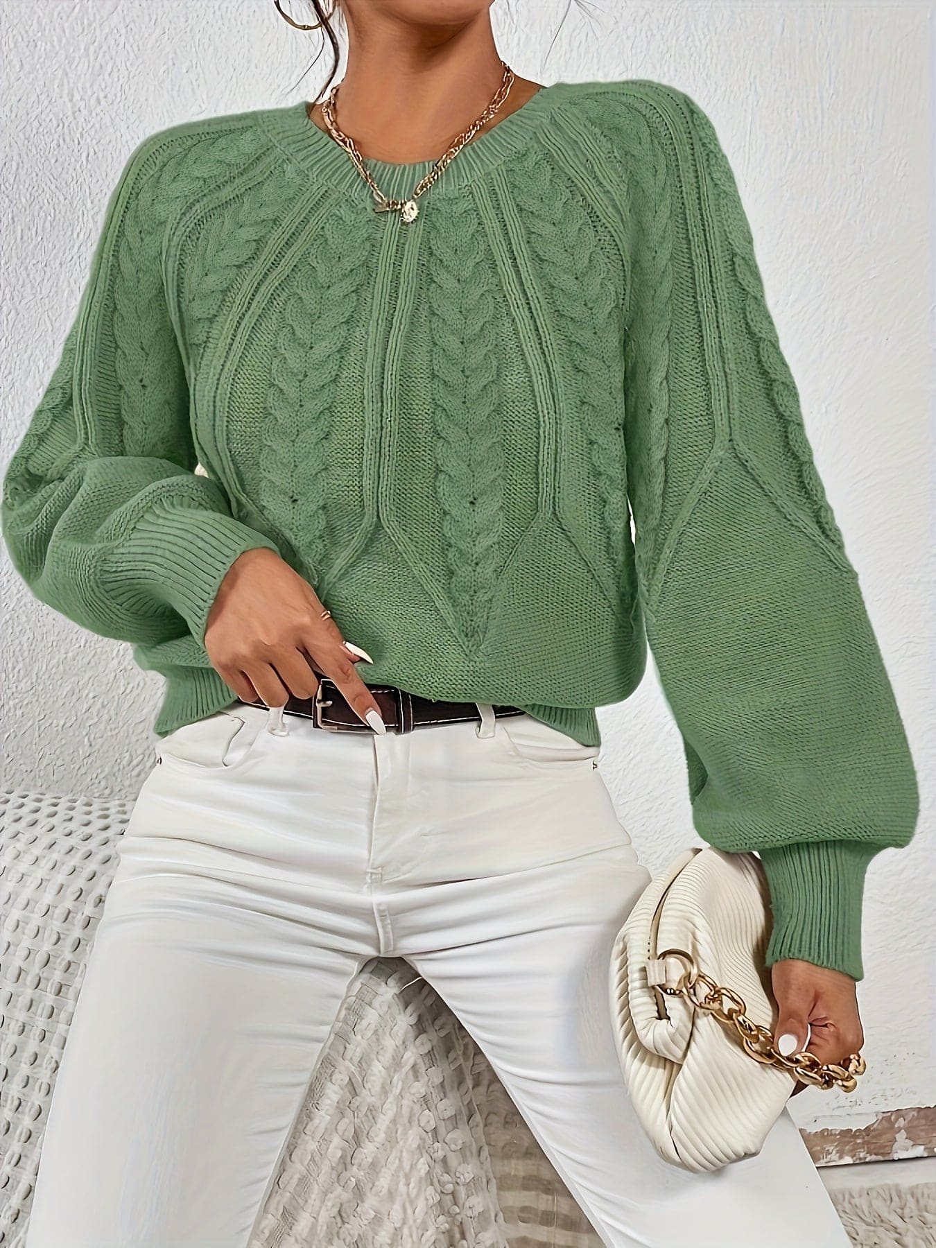 Kvinde set bagfra iført strikket sweater med kabelmønster og ballonærmer._3