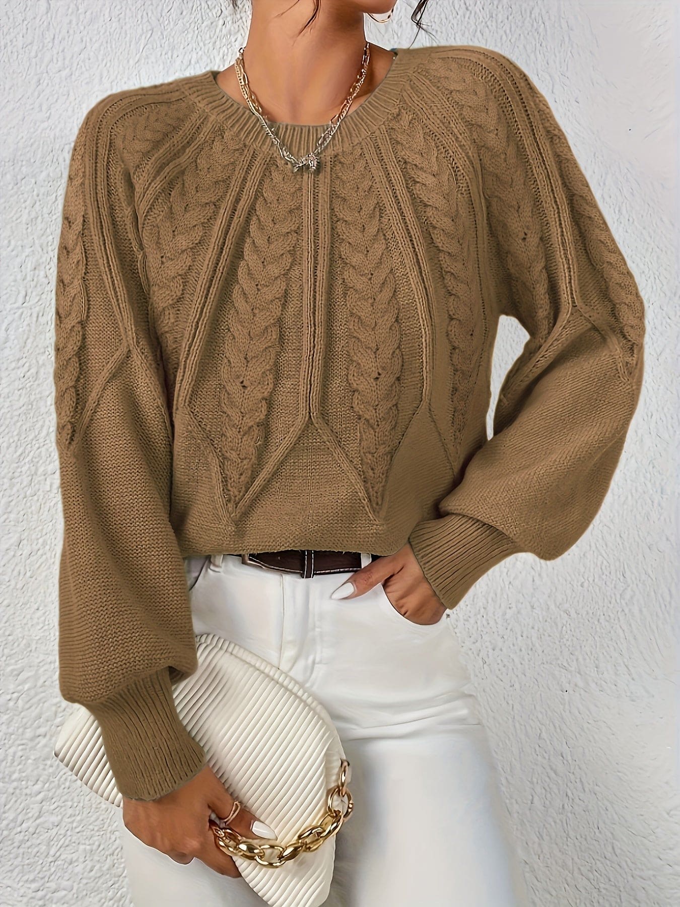 Kvinde set bagfra iført strikket sweater med kabelmønster og ballonærmer._34