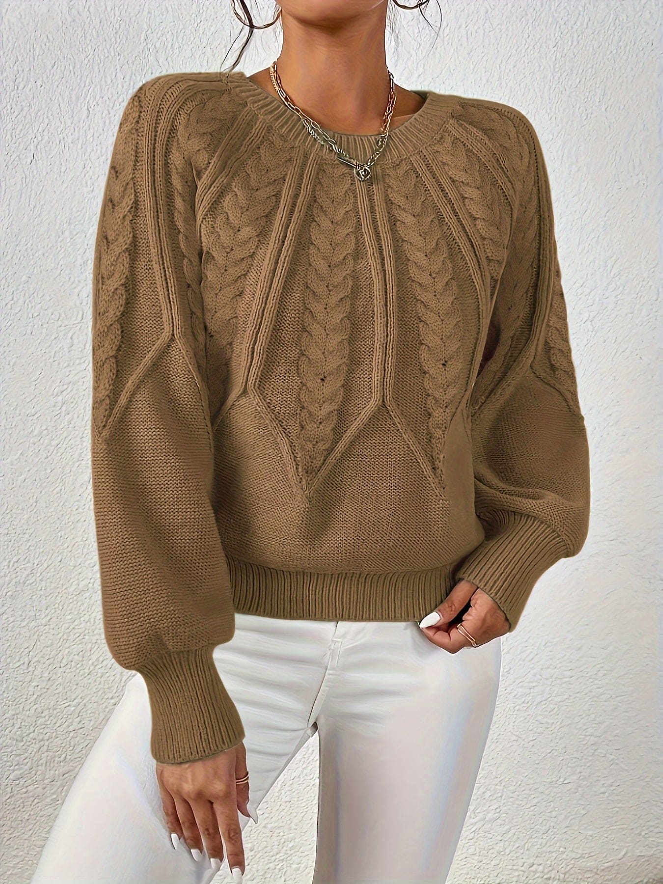Kvinde set bagfra iført strikket sweater med kabelmønster og ballonærmer._37