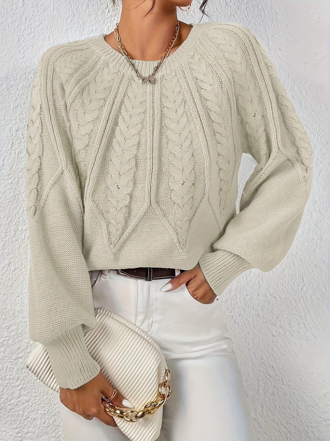Kvinde set bagfra iført strikket sweater med kabelmønster og ballonærmer._4