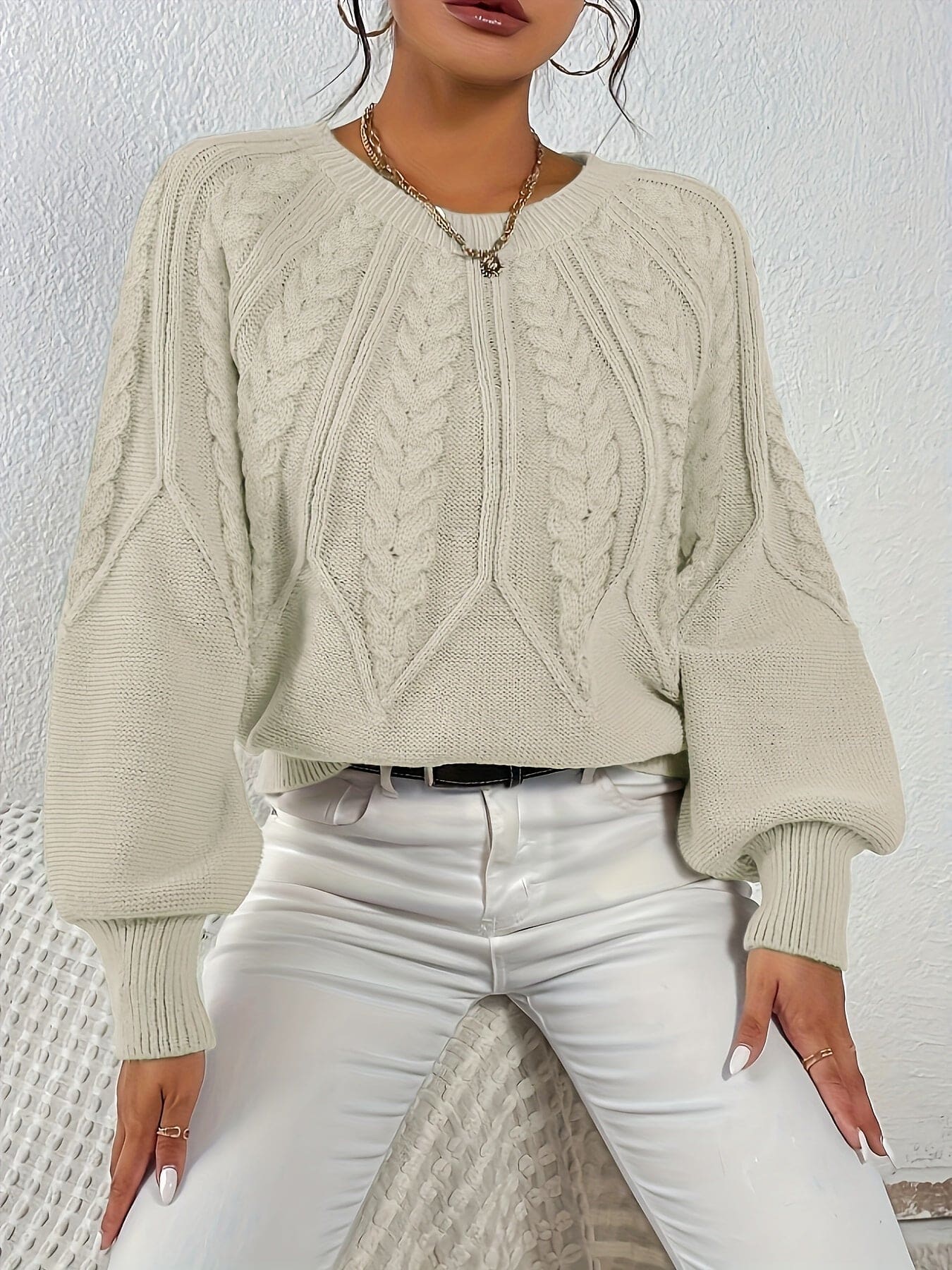 Kvinde set bagfra iført strikket sweater med kabelmønster og ballonærmer._6