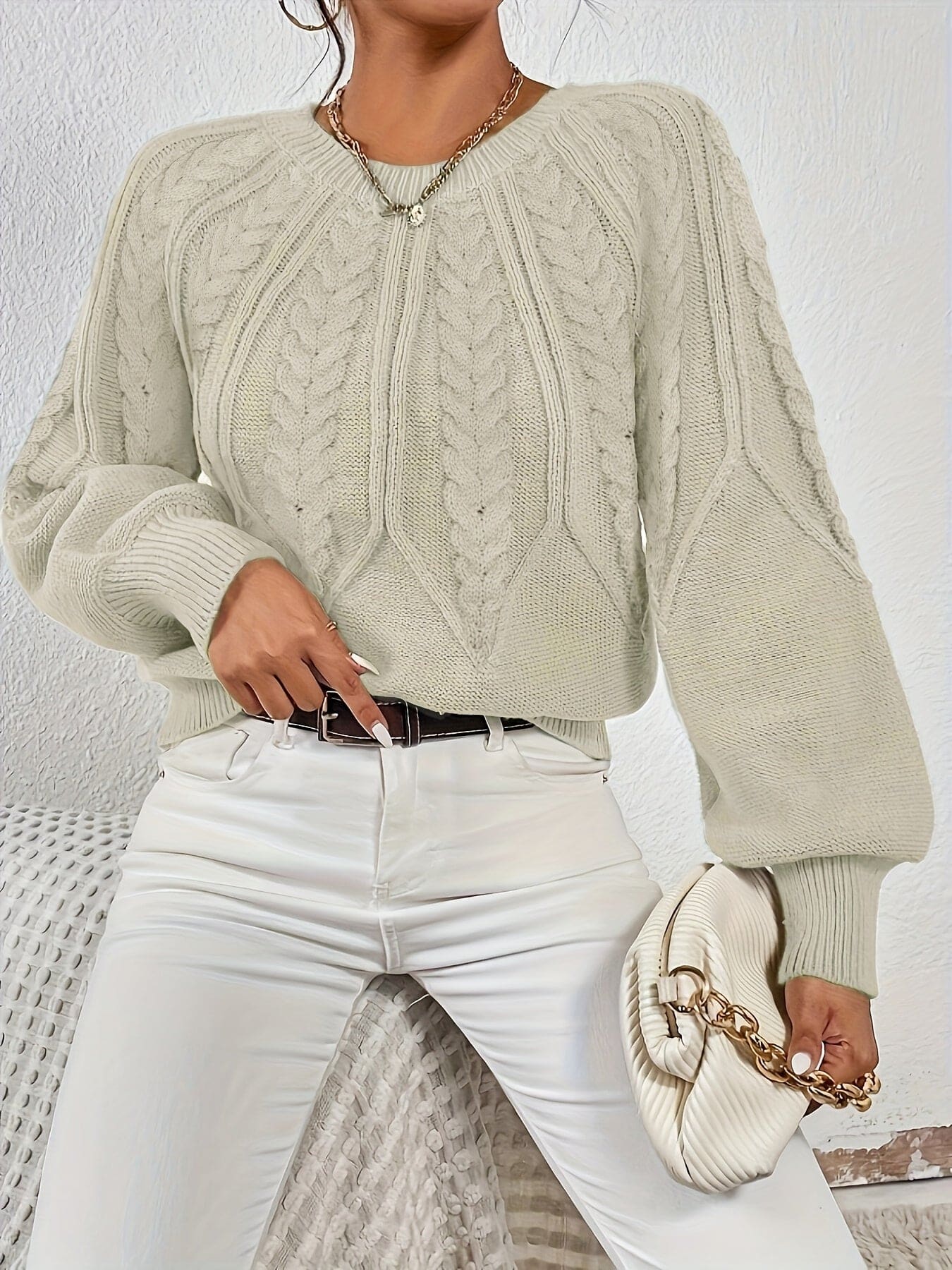Kvinde set bagfra iført strikket sweater med kabelmønster og ballonærmer._8