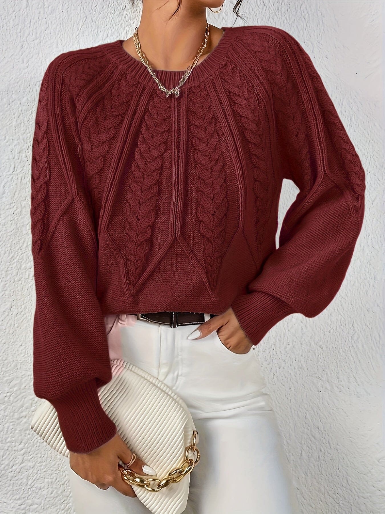 Kvinde set bagfra iført strikket sweater med kabelmønster og ballonærmer._9