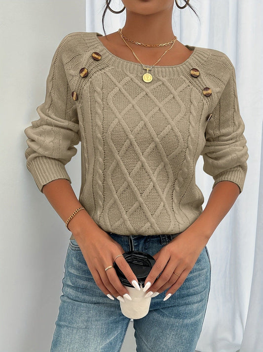 Kvinde iført beige strikket sweater med kabelstruktur og knapper ved skulderen, kombineret med lyse jeans_0