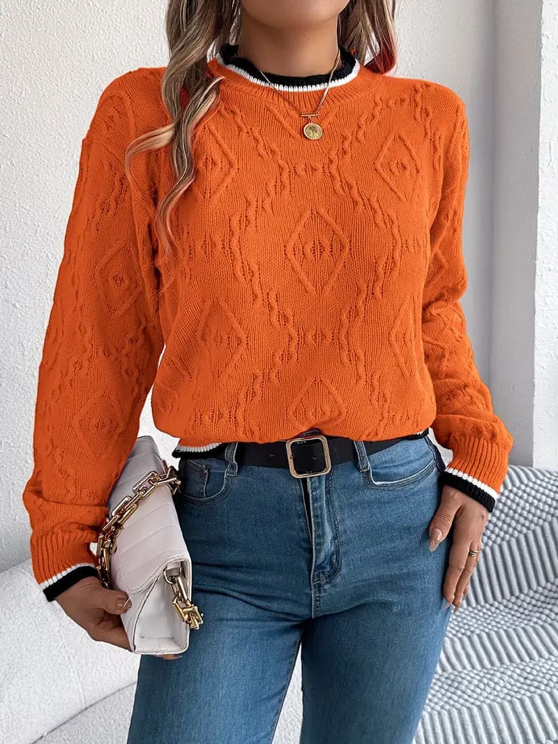 Kvinde iført beige strikket sweater med kontrastdetaljer og jeans foran lys baggrund_12
