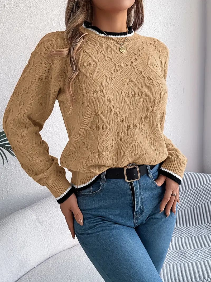 Kvinde iført beige strikket sweater med kontrastdetaljer og jeans foran lys baggrund_15
