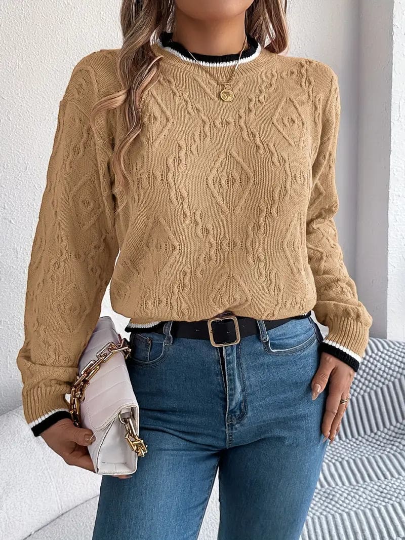 Kvinde iført beige strikket sweater med kontrastdetaljer og jeans foran lys baggrund_16