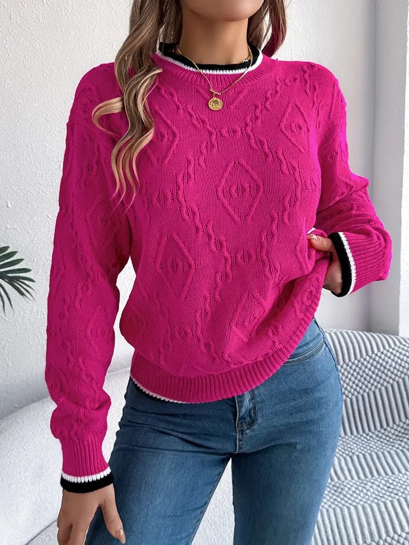 Kvinde iført beige strikket sweater med kontrastdetaljer og jeans foran lys baggrund_3