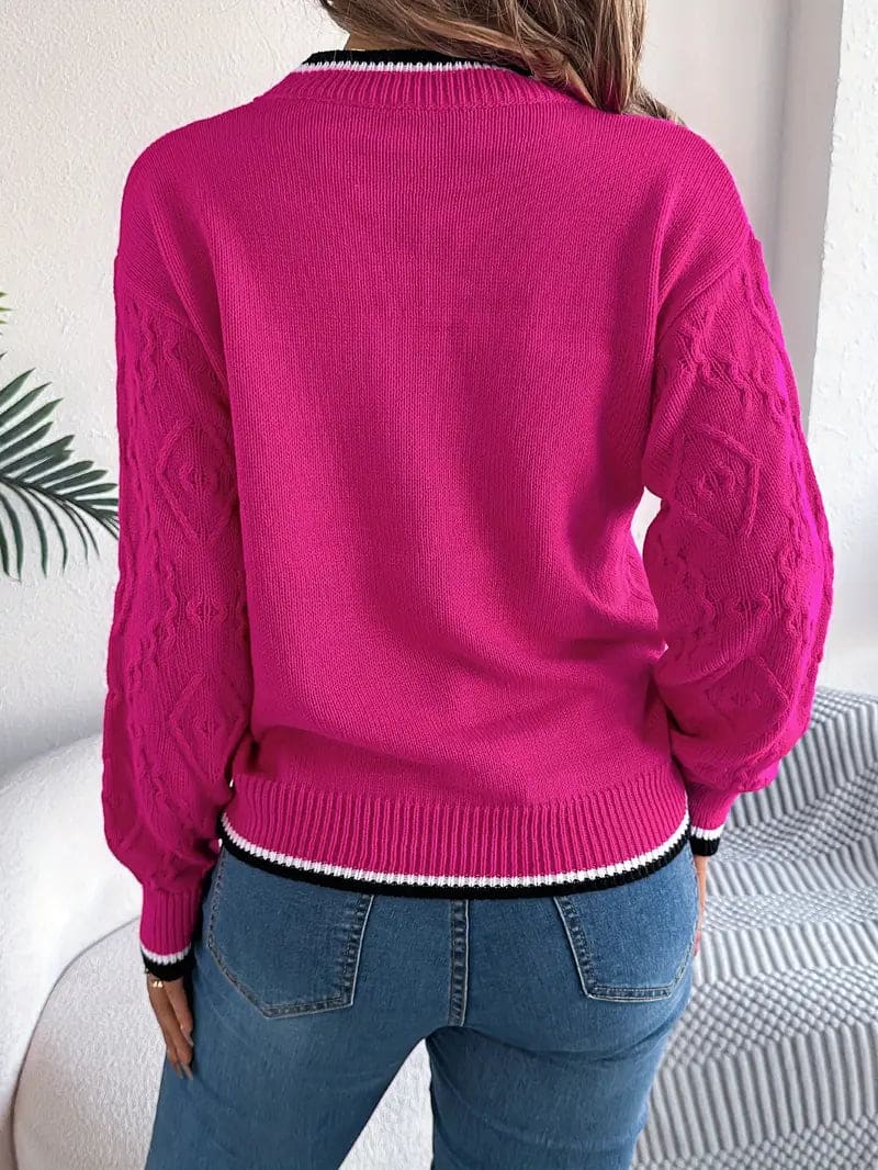 Kvinde iført beige strikket sweater med kontrastdetaljer og jeans foran lys baggrund_4