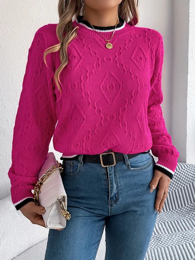 Kvinde iført beige strikket sweater med kontrastdetaljer og jeans foran lys baggrund_7