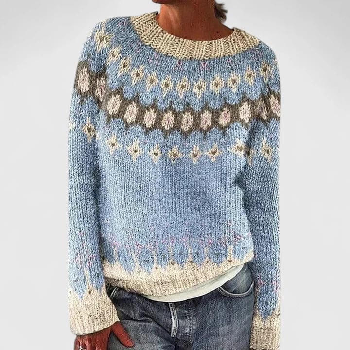 Kvinde iført en strikket sweater med nordisk mønster i lyseblå og beige nuancer, rund hals og afslappet pasform._0