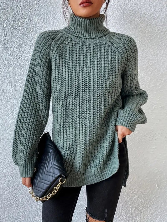 Model iført en grøn oversize turtleneck sweater med textureret strik og høj krave, stylet med sorte bukser og en quiltet taske._0