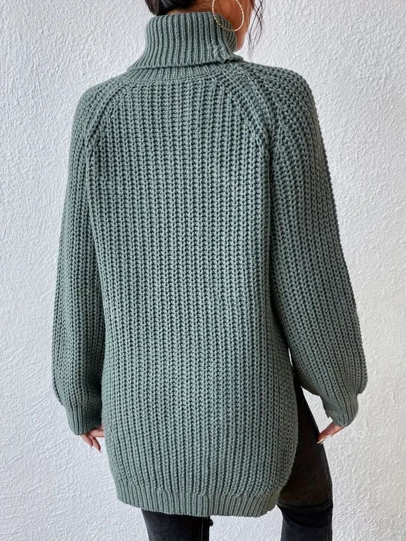 Model iført en grøn oversize turtleneck sweater med textureret strik og høj krave, stylet med sorte bukser og en quiltet taske._1
