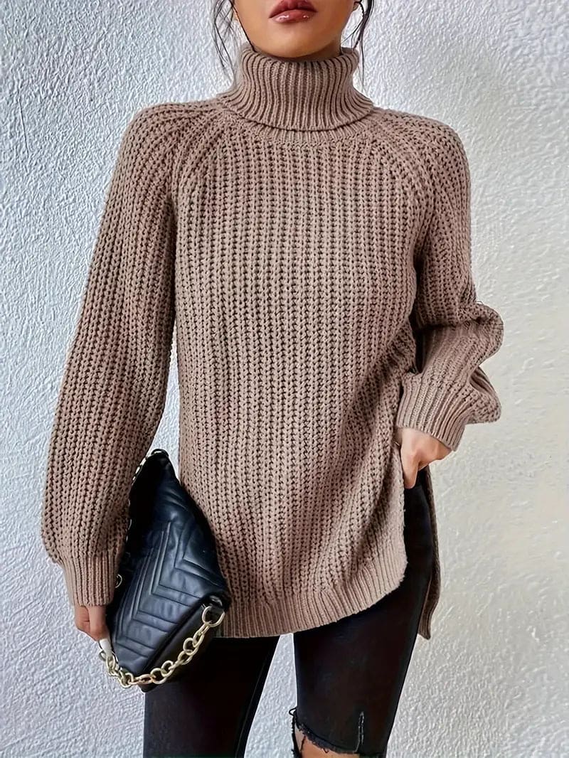 Model iført en grøn oversize turtleneck sweater med textureret strik og høj krave, stylet med sorte bukser og en quiltet taske._10