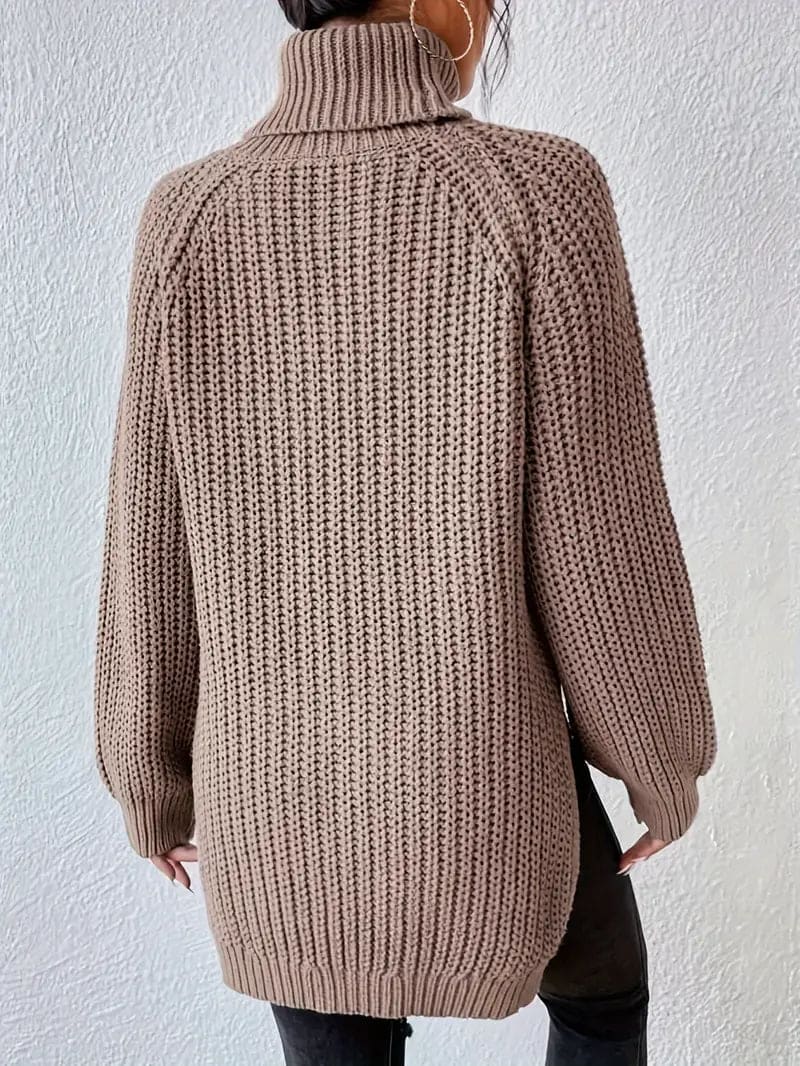 Model iført en grøn oversize turtleneck sweater med textureret strik og høj krave, stylet med sorte bukser og en quiltet taske._11