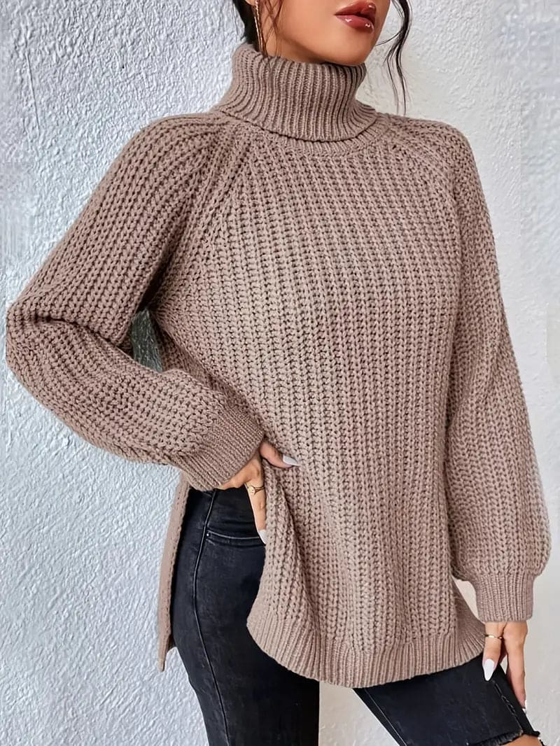 Model iført en grøn oversize turtleneck sweater med textureret strik og høj krave, stylet med sorte bukser og en quiltet taske._13
