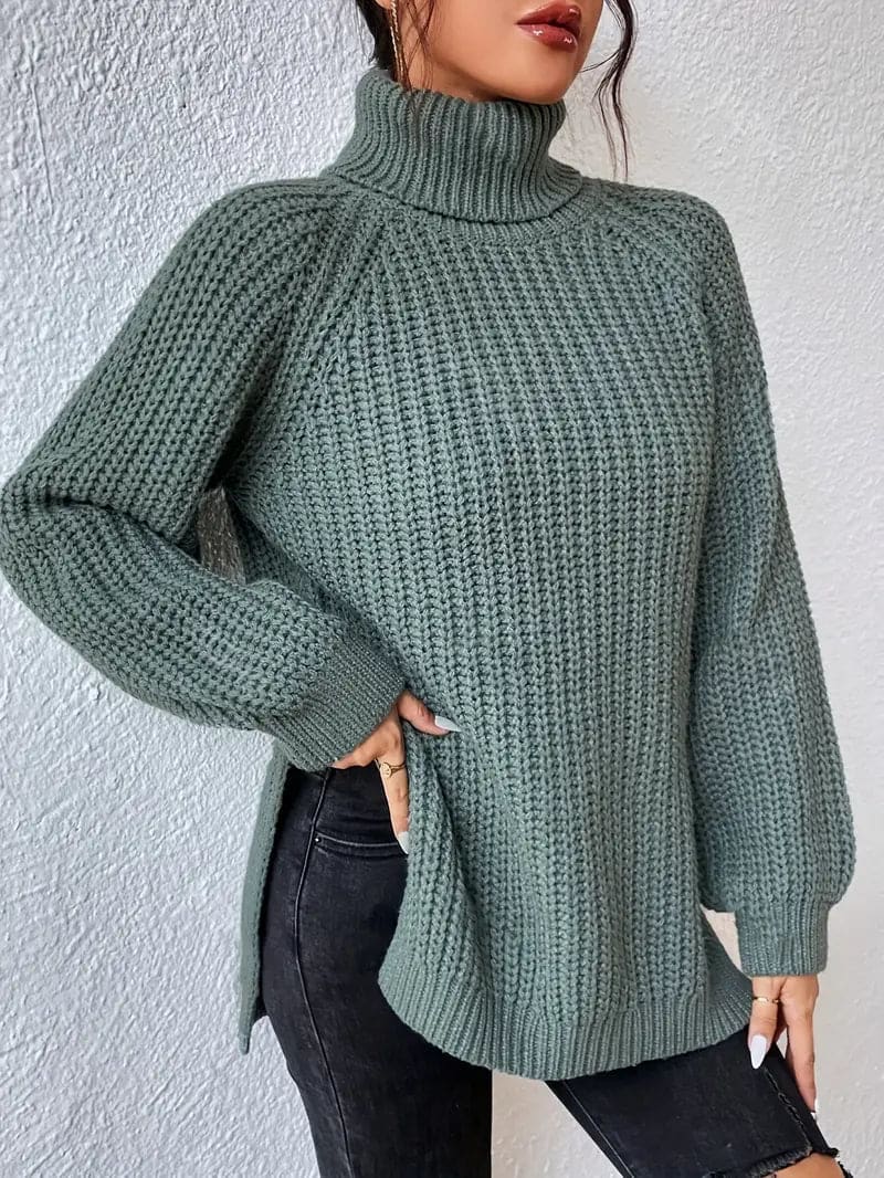 Model iført en grøn oversize turtleneck sweater med textureret strik og høj krave, stylet med sorte bukser og en quiltet taske._3