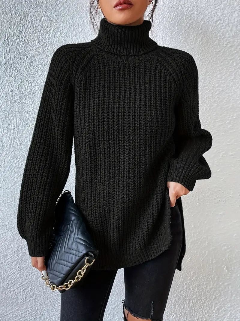 Model iført en grøn oversize turtleneck sweater med textureret strik og høj krave, stylet med sorte bukser og en quiltet taske._5