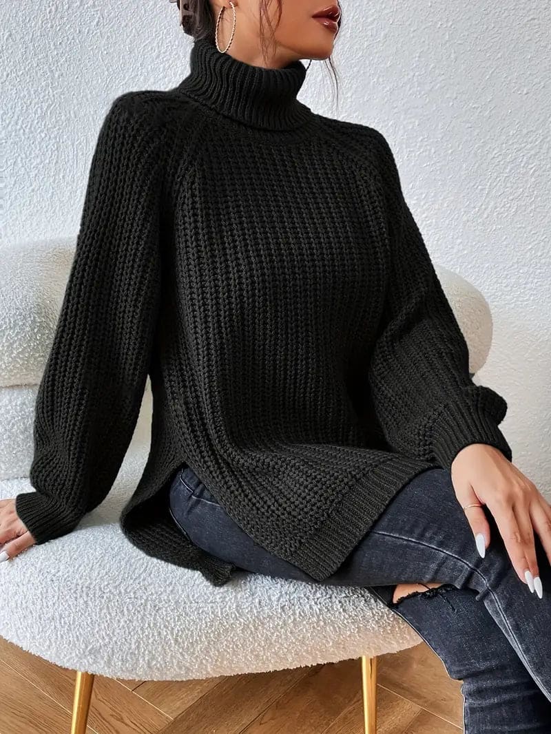 Model iført en grøn oversize turtleneck sweater med textureret strik og høj krave, stylet med sorte bukser og en quiltet taske._7