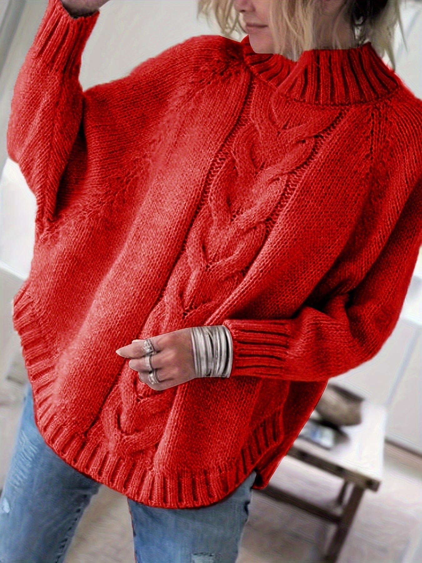 Kvinde iført sweater med høj hals, markante snoninger og afslappet pasform._0