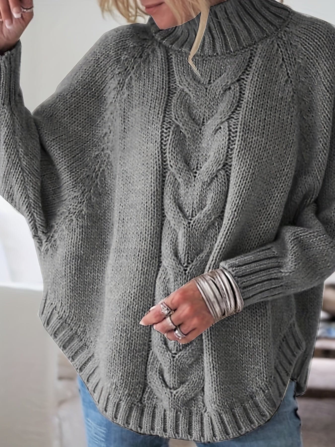 Kvinde iført sweater med høj hals, markante snoninger og afslappet pasform._3