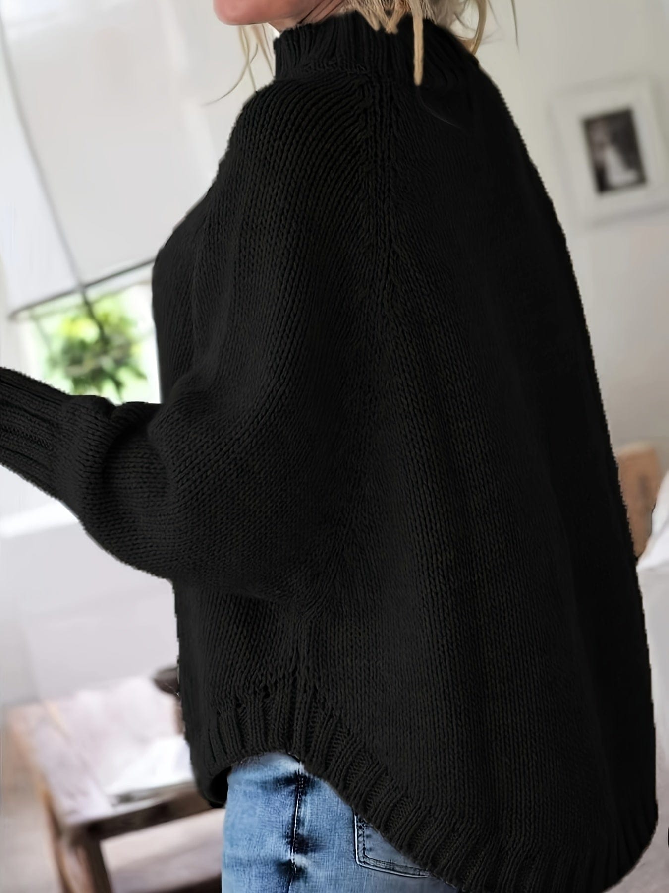 Kvinde iført sweater med høj hals, markante snoninger og afslappet pasform._5